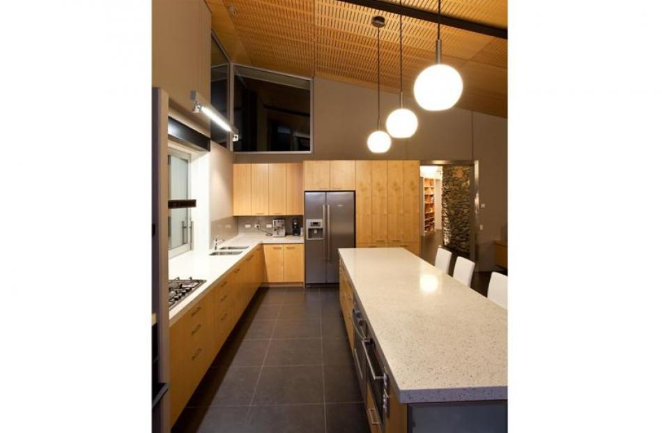 Timber accoustic ceiling panels offset the ceramic floor tiles in the kitchen.