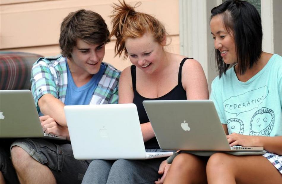 Students (from left) Nate Parker, Heidi Ashby and Jeni Chang (all 20) work on their laptops...