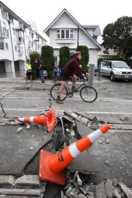 A cyclist on a damaged road in Christchurch. Photo: NZPA / Ashburton Guardian, Kirsty Graham