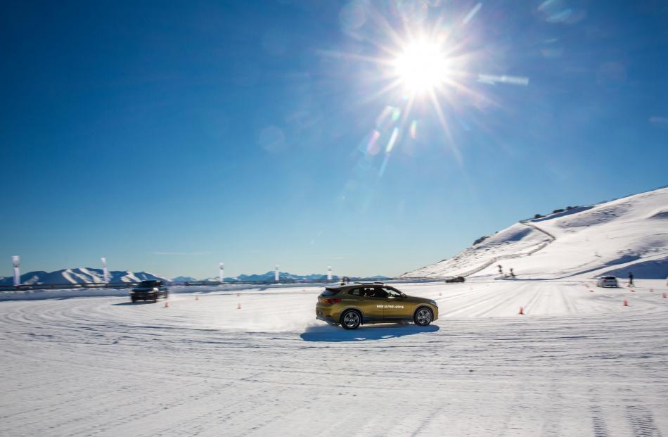 Tackling the snow slalom course in four-wheel-drive BMWs.