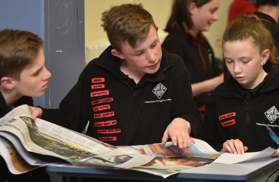 Ted McFadgen (12), Ben Turnbull (13) and Georgia Te Raki (11), from Fairfield School, scour the Otago Daily Times for last night’s Extra! current events quiz.