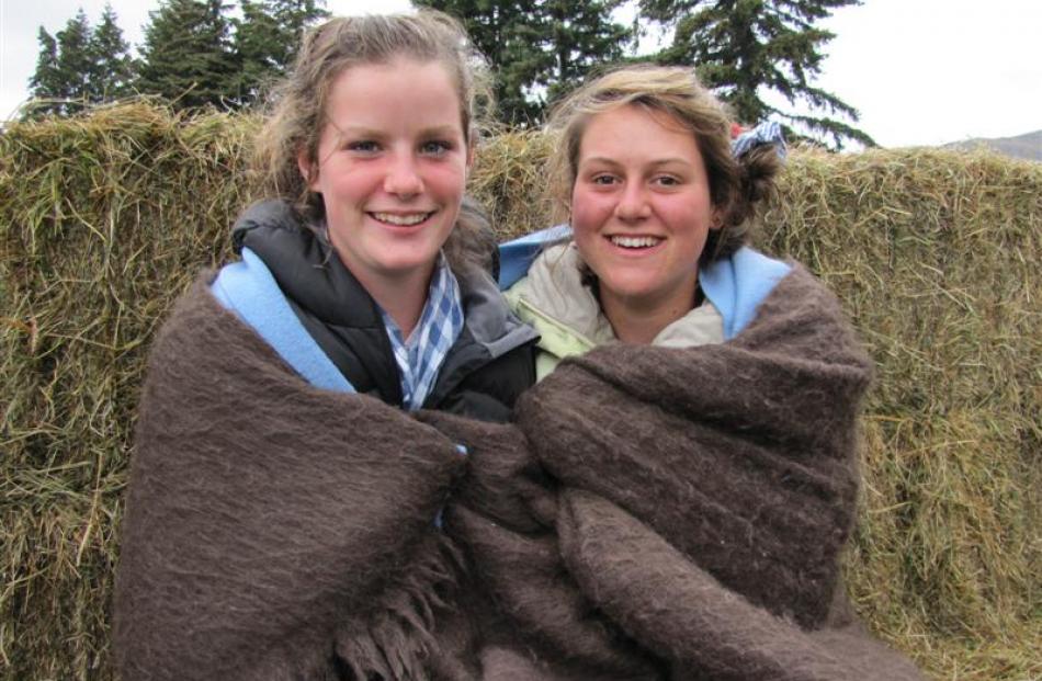 From left, Bella Nolan and Lucy Kissling (both 14), of Mount Aspiring College, rug up on a rainy...