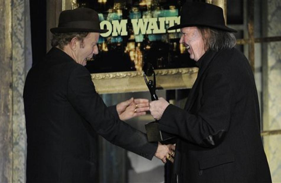 Tom Waits, left, accepts his trophy from Neil Young. (AP Photo/Evan Agostini)