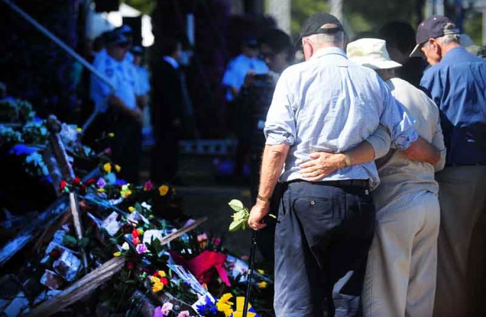 Mourners place flowers.