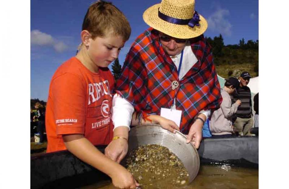 Jack Mullany (10), of Dunedin, pans for gold helped by Margaret May, of Ettrick. Photo by Jane...