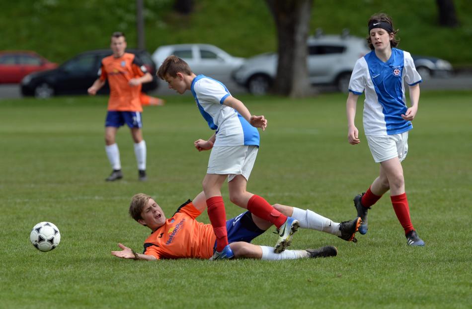 Nelson Bays player Alex Ward struggles to get up while Nomads United players Liam Perriman (centre) and Riley Behrnes look on.