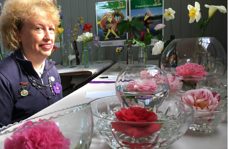 Lowcliffe WI member Susan Philpott looks at the ``floating Camellia in glass container'' entries.