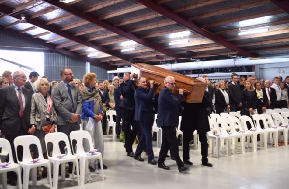 Nick Wallis' coffin is carried into the Alpine Helicopters hangar. Photo: Stephen Jaquiery