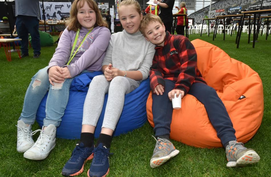 Alex Barkman (10, left), Rosa van Turnout (11) and Seth Kyle (8) take in the atmosphere at the...