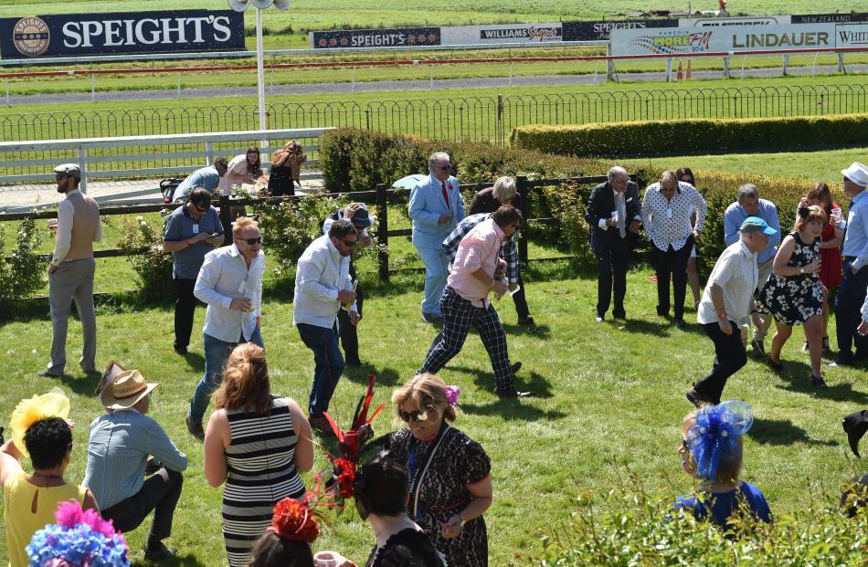 Crowd members duck as thousands of bees swarm through the field. Photos: Peter McIntosh