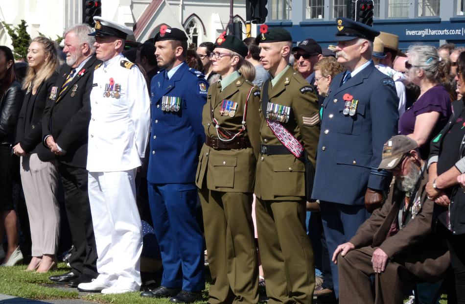 Members of the armed services look on with members of the public during the Armistice Day service...