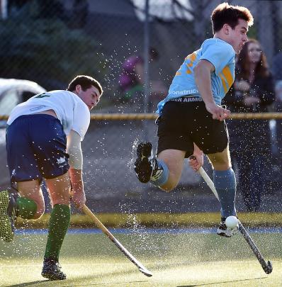 Spray kicked up from the wet ground is illuminated by low afternoon sun as Craig Turner (left), of Kings United, and Callum Dempster, of University, contest the ball during the men’s premier hockey final at the Alexander McMillan Turf in August. Photo: Pe Spray kicked up from the wet ground is illuminated by low afternoon sun as Craig Turner (left), of Kings United, and Callum Dempster, of University, contest the ball during the men’s premier hockey final at the Alexander McMillan Turf in August. Photo: Pe