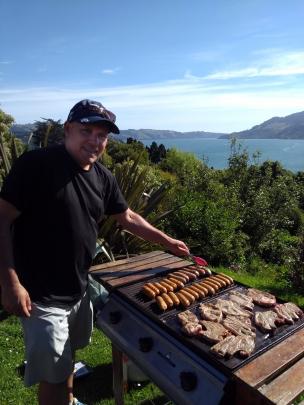 Leroy Parker cooks a Christmas Eve meal in Port Chalmers, overlooking the inner harbour towards Dunedin. Photo: Malcolm Parker