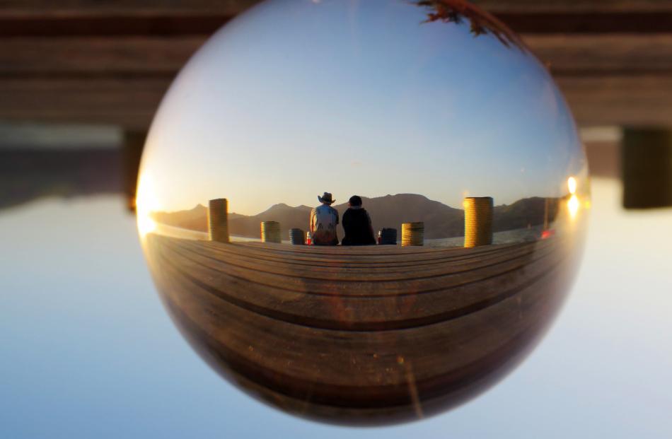 Jordan and Cameron Dargaville watch the sun set at Harwood on Christmas Day. The photo was taken through a lens ball. Photo: Browyn Dargaville
