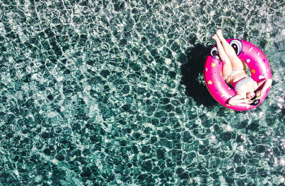 Lucy Ward treats herself to a doughnut on a stunning day in Glendhu Bay. Photo: Liam Toomey