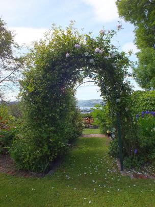 A rose arch frames a harbour view. 