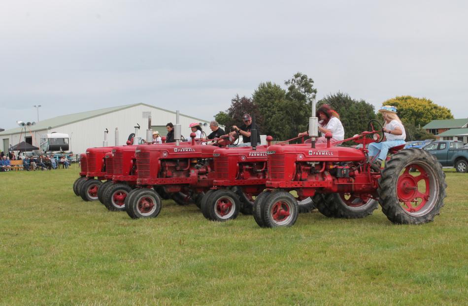 Couples drives vintage tractors into chains in front of the audience.