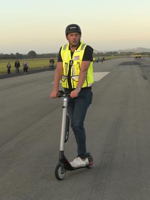Dunedin Airport chief executive Richard Roberts directs traffic on an electric scooter.