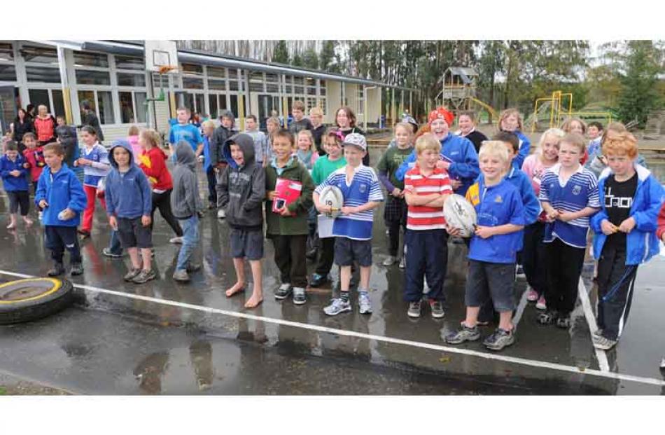 Eager Heriot school pupils wait, some barefoot, to welcome the Highlanders.