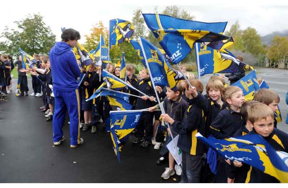 Nick Crosswell hands out flags to children at Tapanui school.