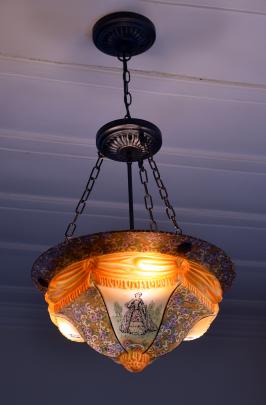 The owners have replaced all the home's paper shades with old light fixtures. This one has women...