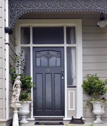 A statue and urns welcome visitors to the front door. 