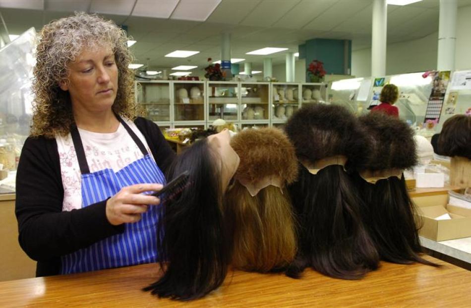 Lynda Dockerty brushes a partly-completed wig.