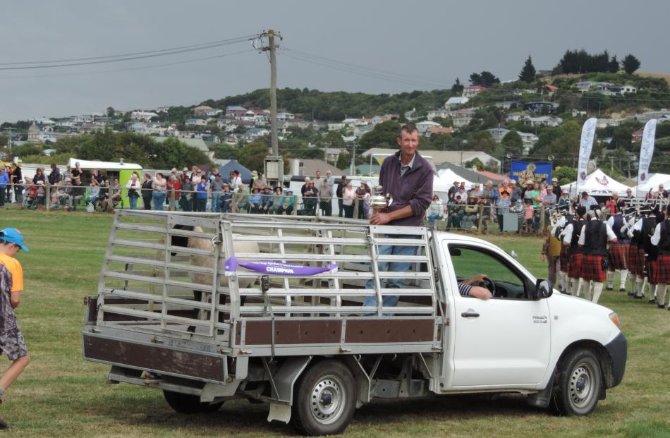 Maheno farmer Kerry Dwyer displays his champion Suffolk sheep, and the trophy it won, in the...