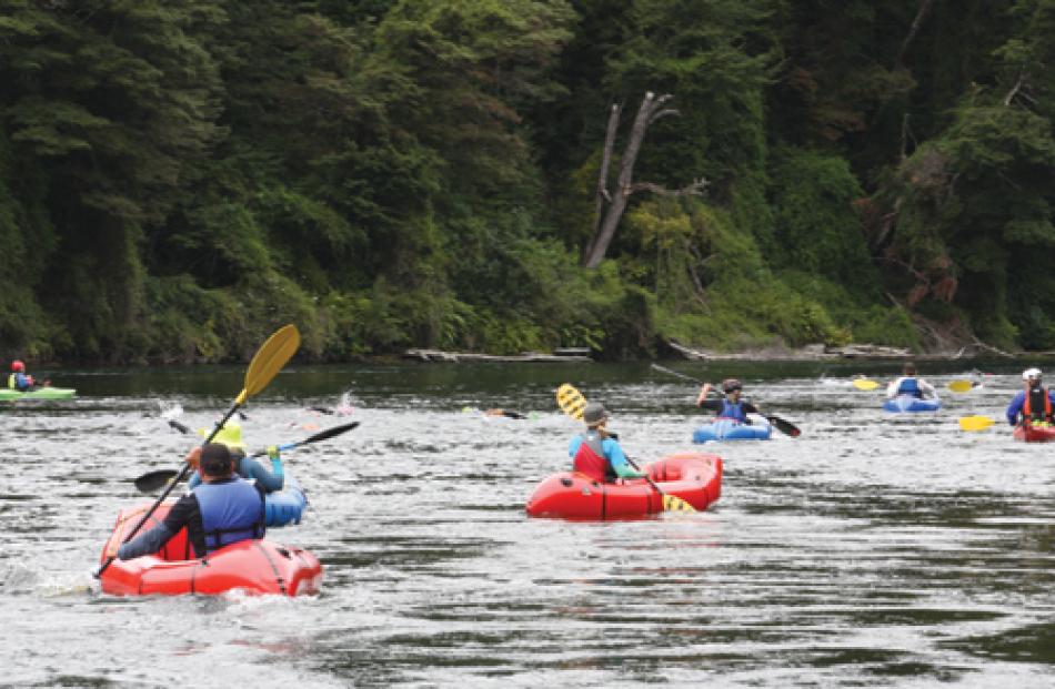 Swimmers navigating the Upper Waiau River during the “fast” swim, with support crews alongside. 