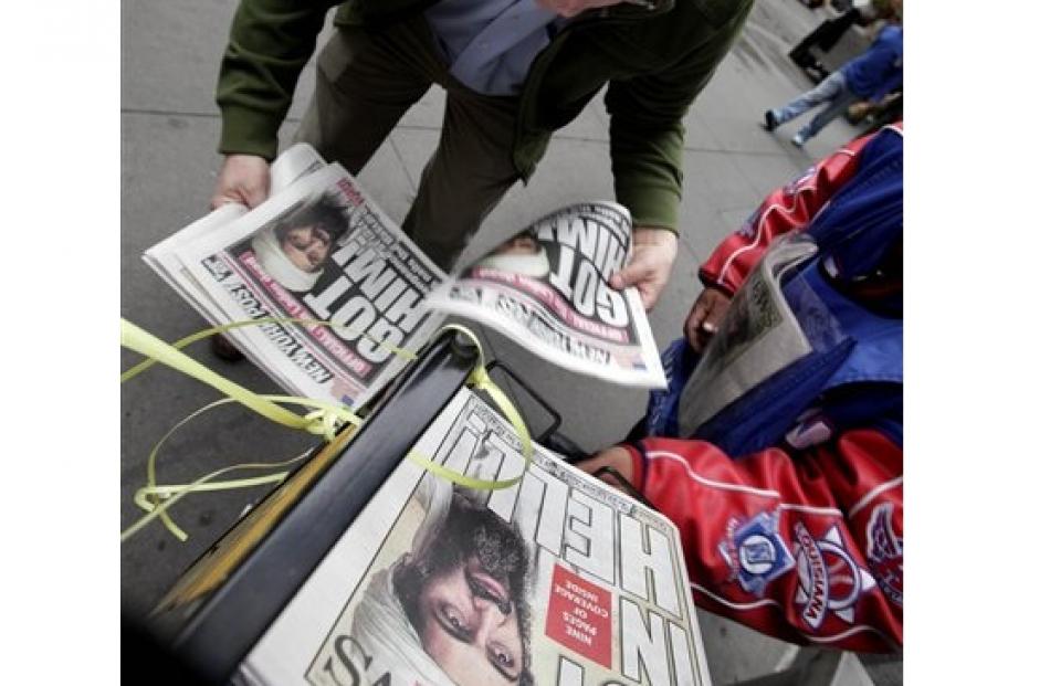 A man buys copies of newspapers in New York's Financial District featuring headlines of the death...