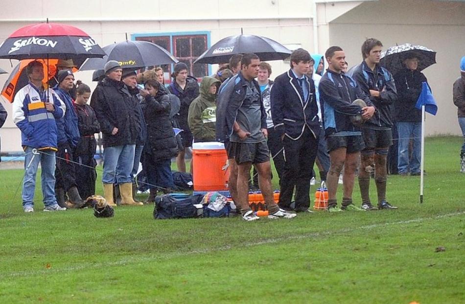 Spectators watch stoically from the sideline.