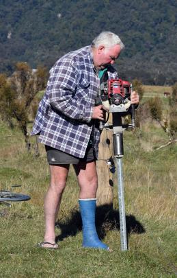Maurice Nolan hammers in waratahs for a holding paddock while nursing a broken leg. Photos:...
