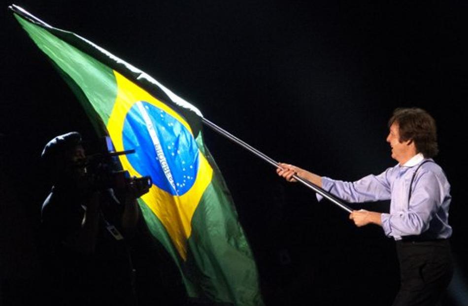 Paul McCartney waves a Brazilian flag during his show in Rio de Janeiro. (AP Photo/Victor R....