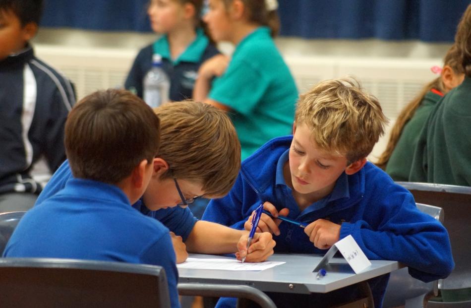 Fenwick School pupil James Soal (10, right) looks over his team's answers alongside Carter...