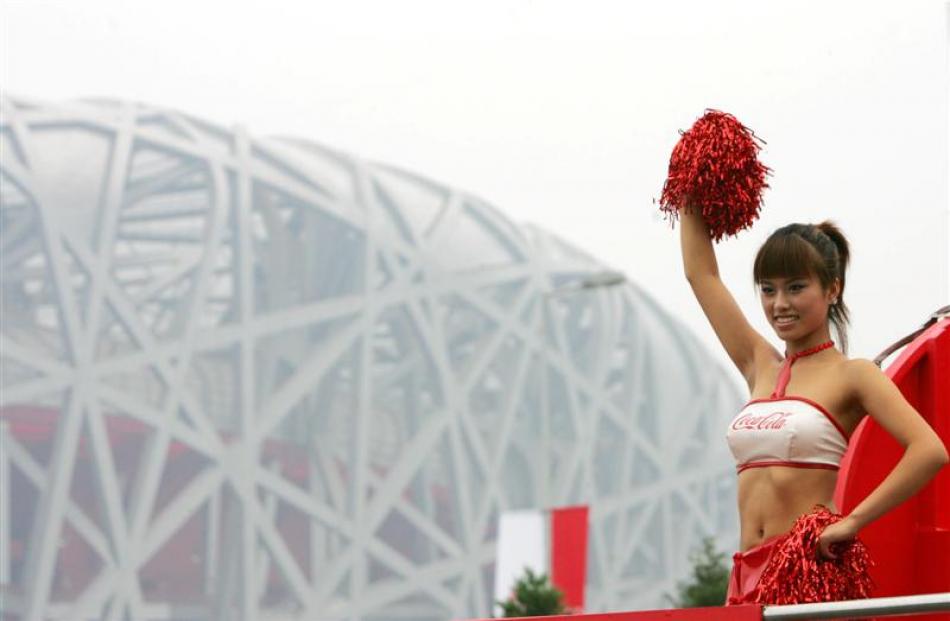 A cheerleader waves during a float parade outside the National Stadium, also known as the Bird's...
