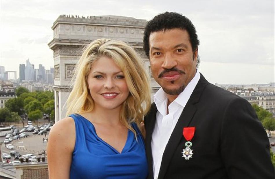 Lionel Richie poses with French actress Celyne Durand in front of the Arc de Triomphe in Paris...