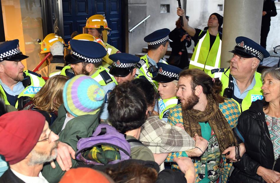 Police and protesters jostle, as officers try unsuccessfully to remove protesters who had linked...