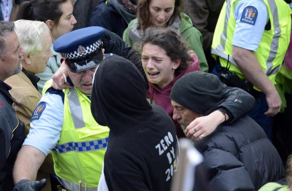 Injured protester and 350 Dunedin member Alva Feldmeier, of Dunedin, is assisted by police and a...