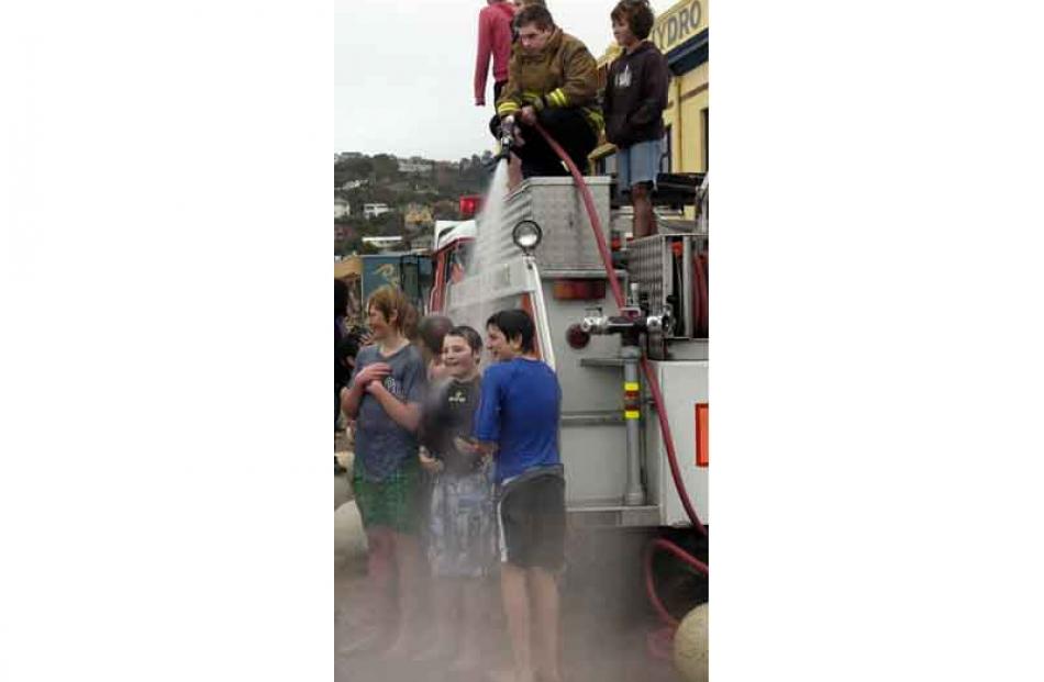 Fire fighter Simon Smith hoses down participants in the annual polar plunge, with some of the...