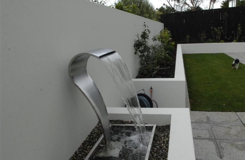 The water feature echoes the clean lines of the house.