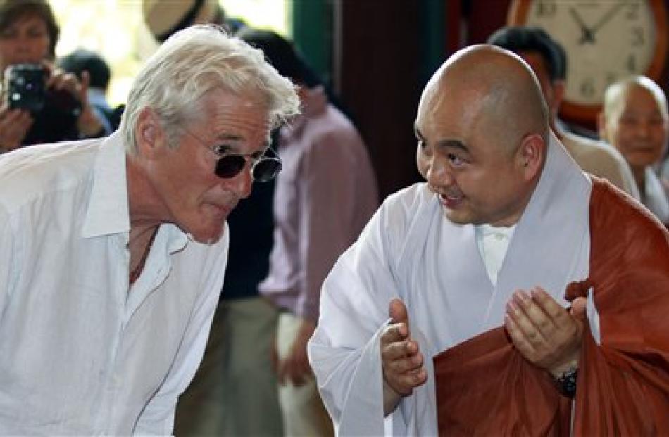 Richard Gere, left, listens to monk Sung Jin during a visit to Chogye temple in Seoul. Gere was...