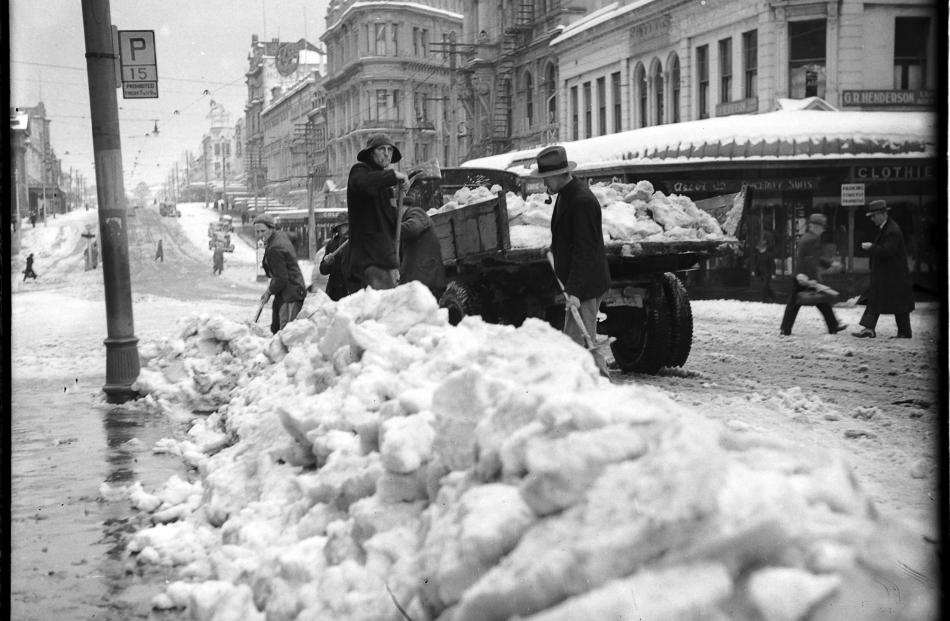 Large quantities of snow were removed from the Exchange, in Dunedin, by men with shovels and...