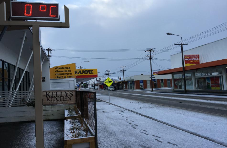 Snow covers the footpath in Milton as the thermometer in town displays the temperature of 0degC. Photo: Richard Davison