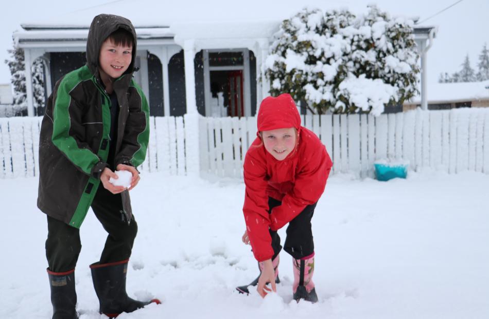 Sam Butler (11) and Molly Butler (13), of Riversdale enjoying  a day off school making snowballs to throw each other. Photo: Sandy Eggleston
