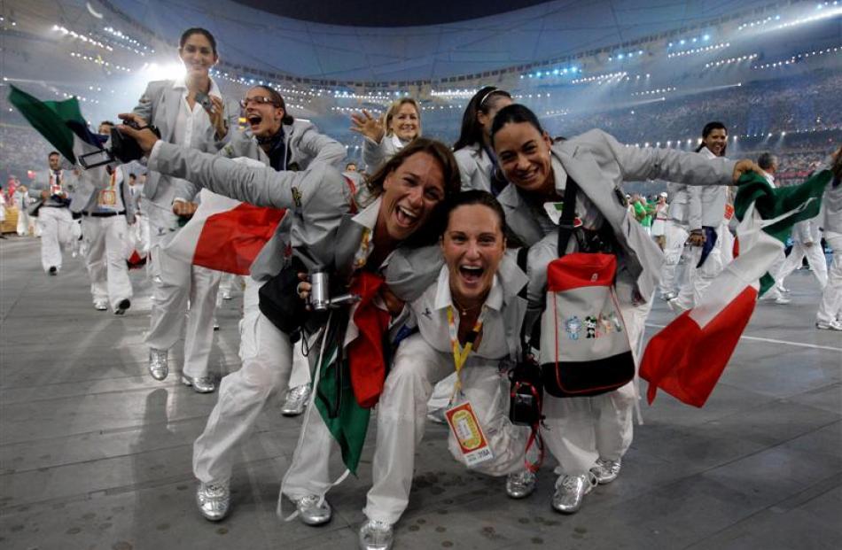 Athletes from Italy cheer as they walk through the National Stadium. (AP Photo/David Phillip)