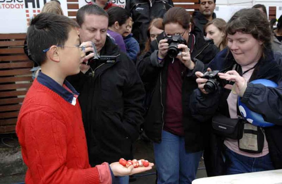 Derek Zhang (11) poses with jaffas he collected for (from left) Tony and Carol Tomek of Australia...