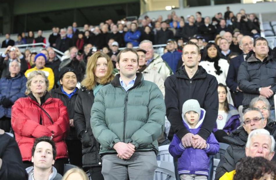 The crowd stands for the national anthem. Photo by Craig Baxter.