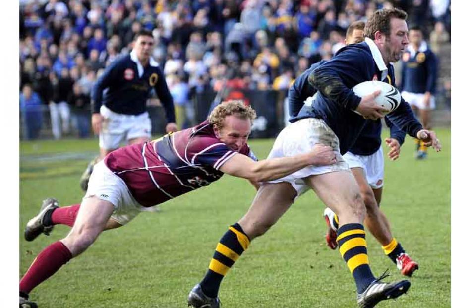 Brendon Laney of Otago Legends XV is held by Dave Elder of the Southland Legends XV.