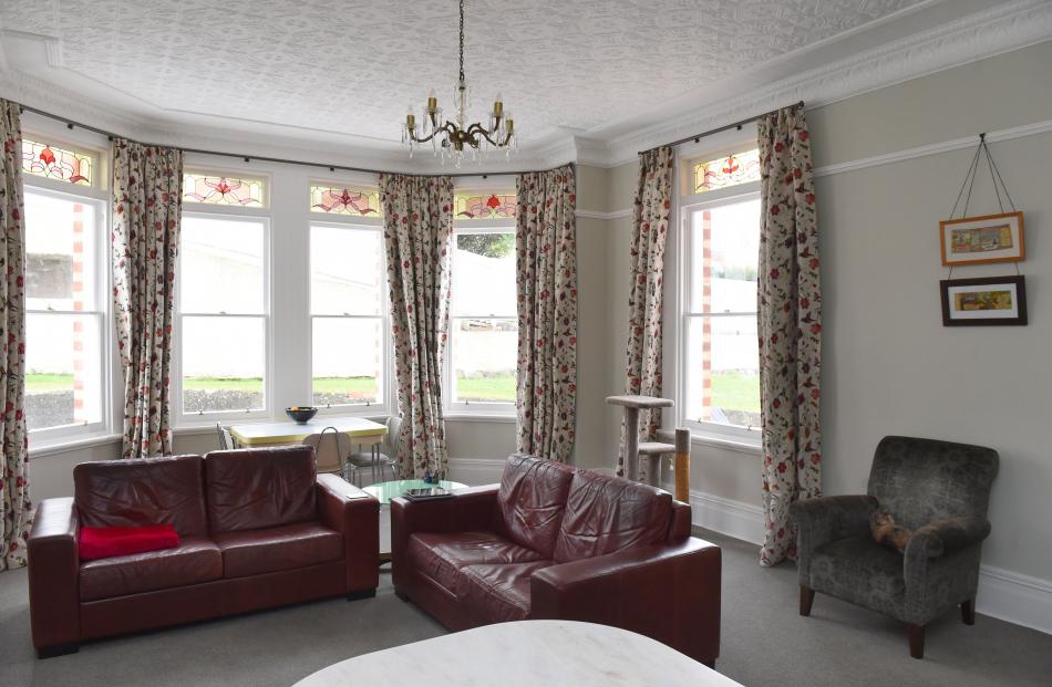 The family room features an original pressed metal ceiling and stained glass windows. 