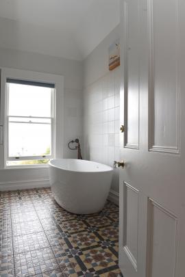 The bathtub in the original bathroom offers views of the city and the coastline. 